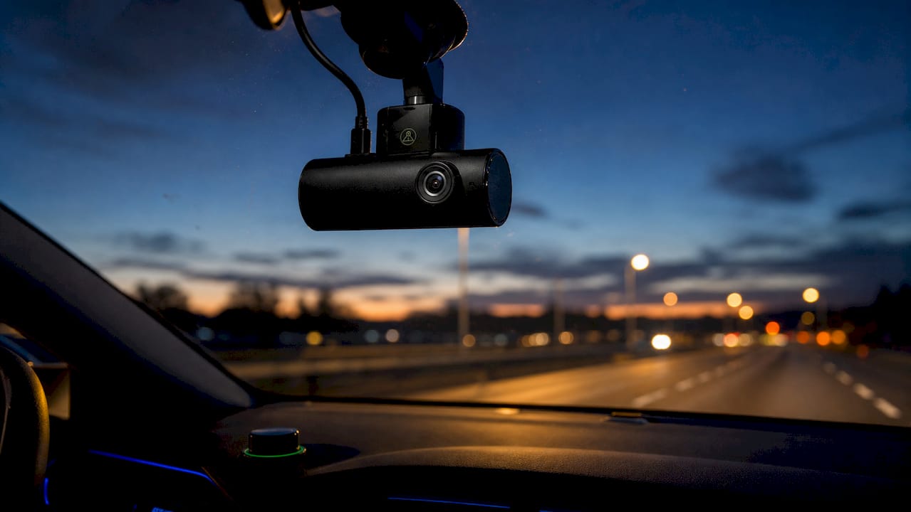 Close-up of dashcam mounted on windshield at dusk