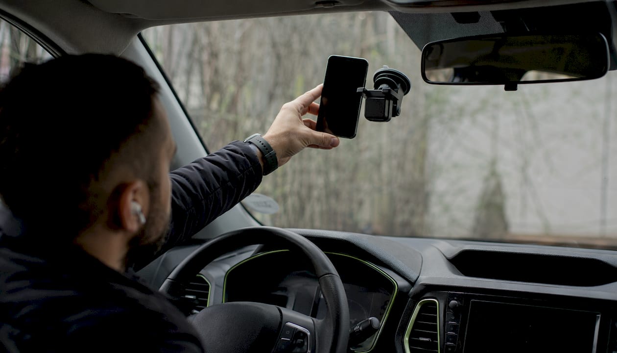 Hand holding Android phone on windshield mount