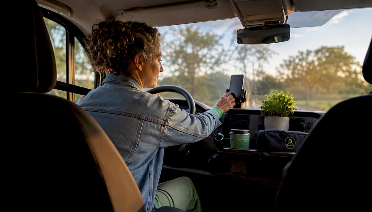 Woman adjusting dashcam app in car