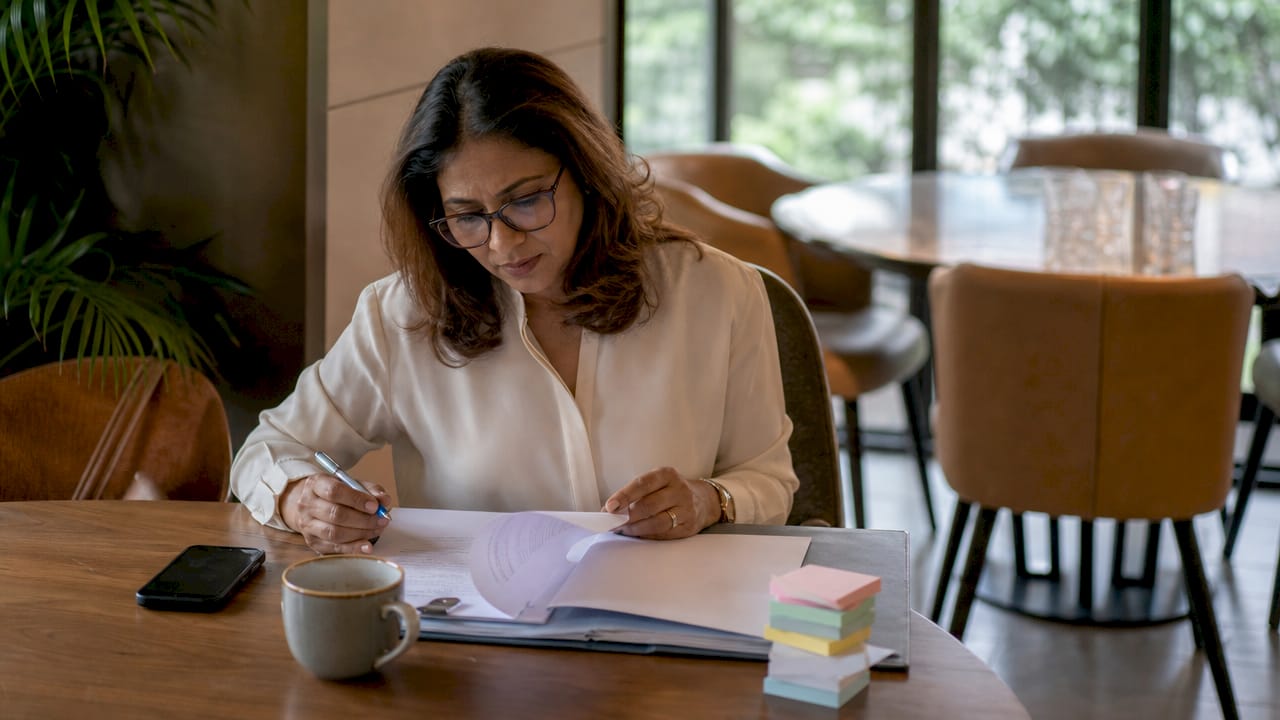 Woman reviewing property documents in home office