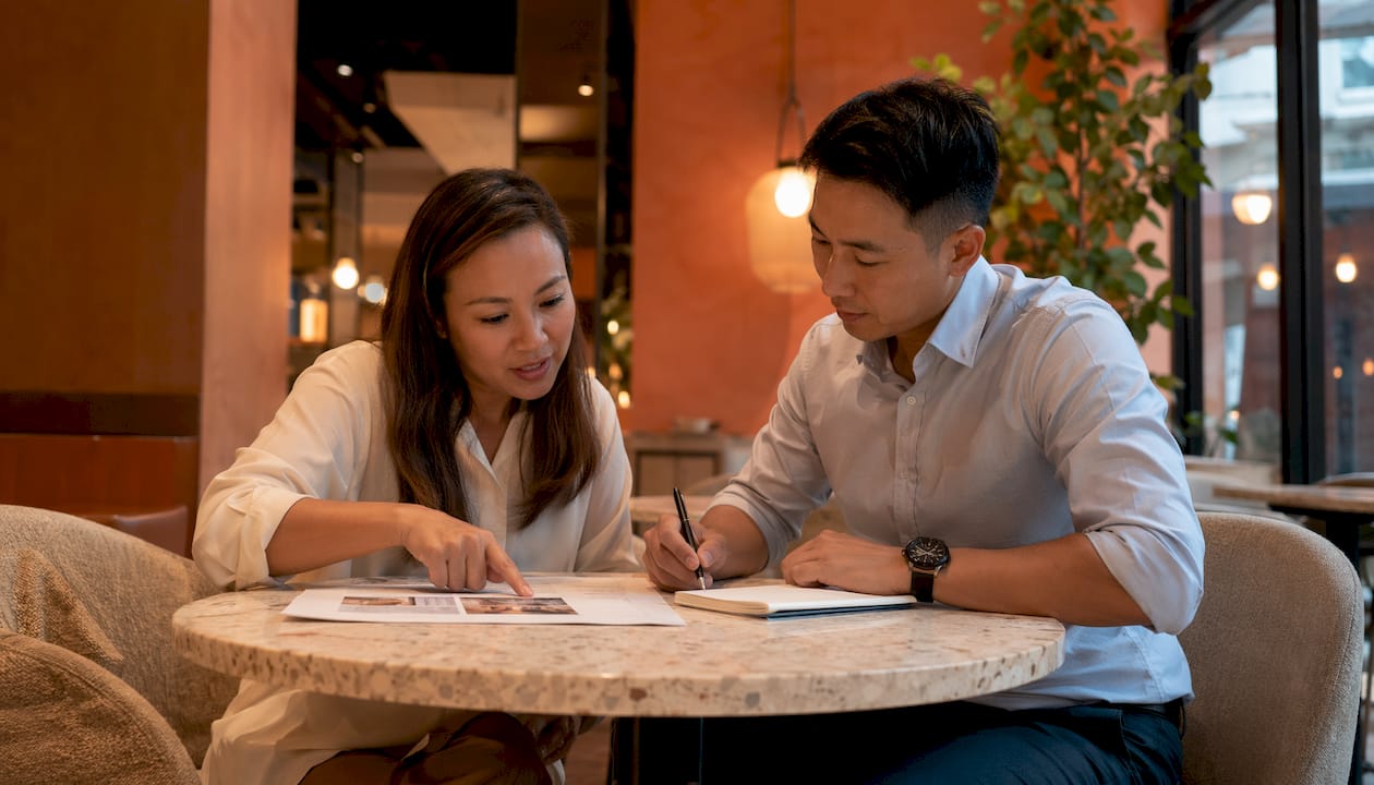 Two professionals discussing property asset plans