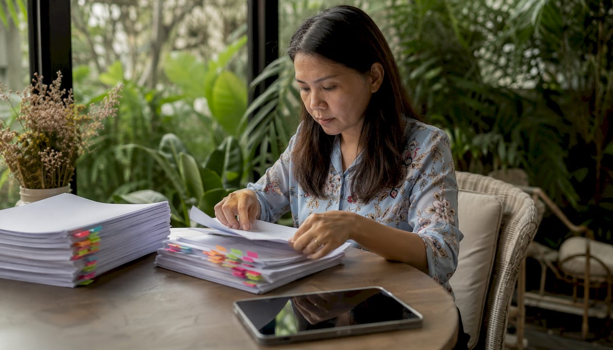 Hands organizing regulatory dossiers and notes