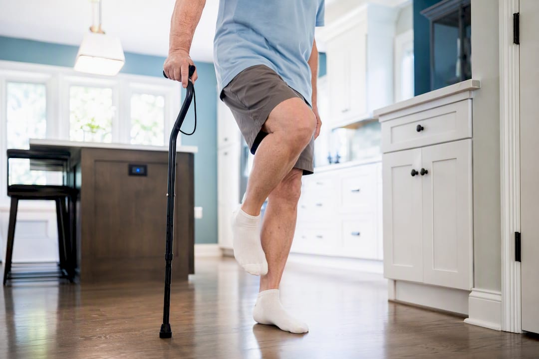 Senior doing one-leg balance exercise with cane