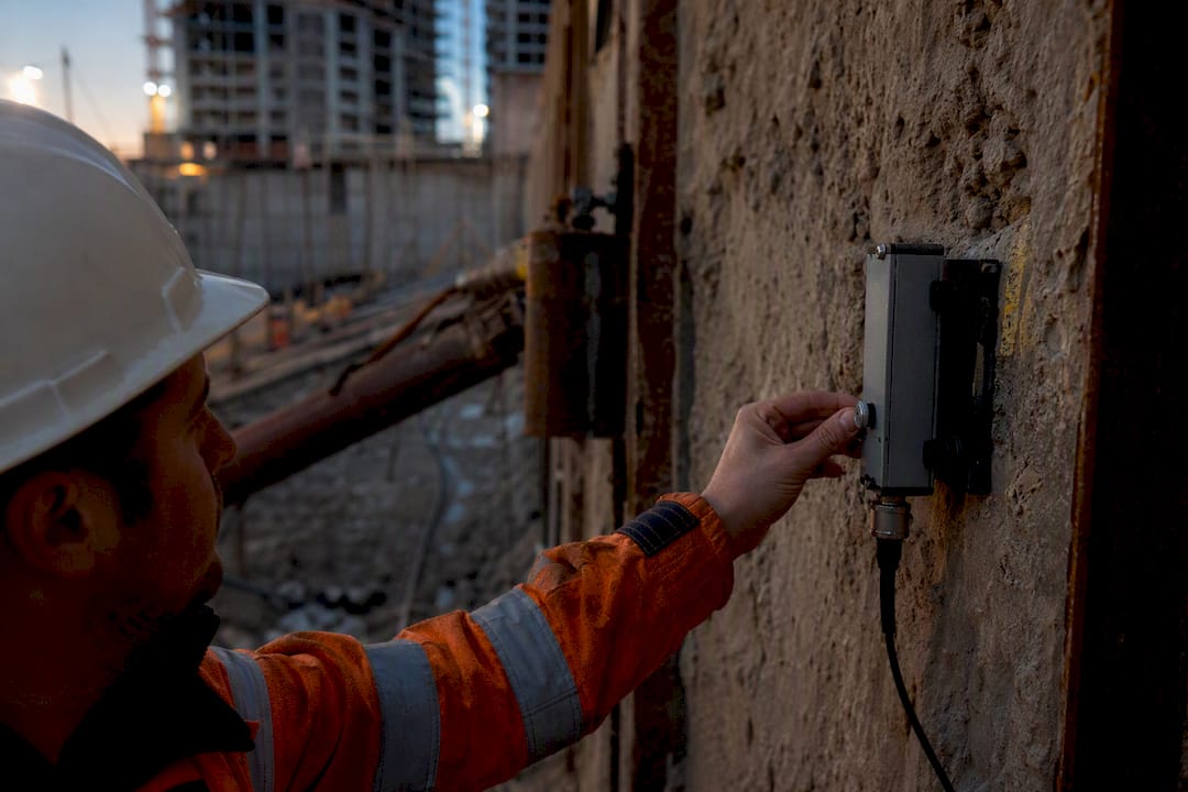 Deep Excavation Monitoring: Methods, Sensors, and Data Hand adjusting sensor device on excavation wall