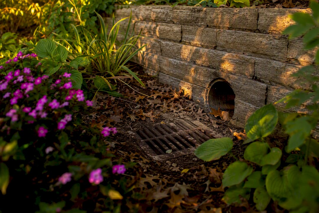 Drainage access grate on retaining wall
