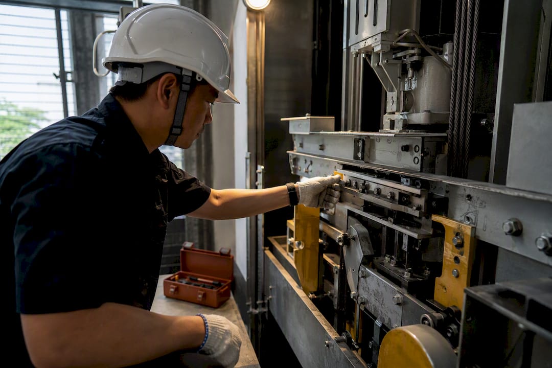 Technician inspecting condominium lift machinery