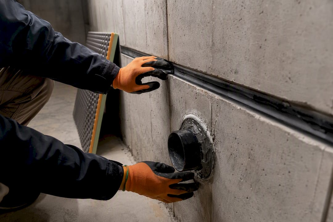 Inspector checking basement joint waterproofing detail