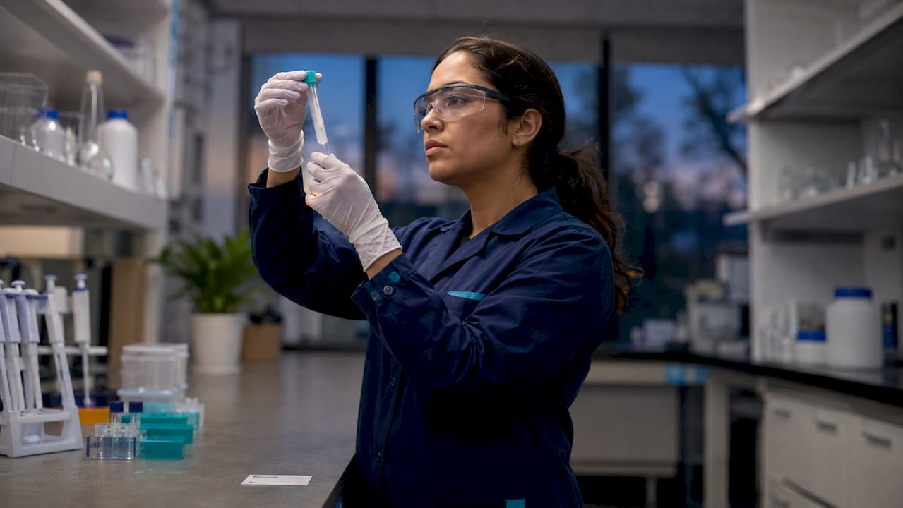 Lab technician inspecting clinical sample closely