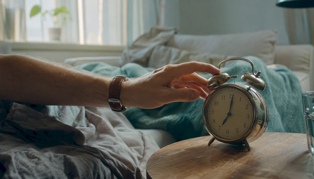 Hand reaching to alarm clock after sleep