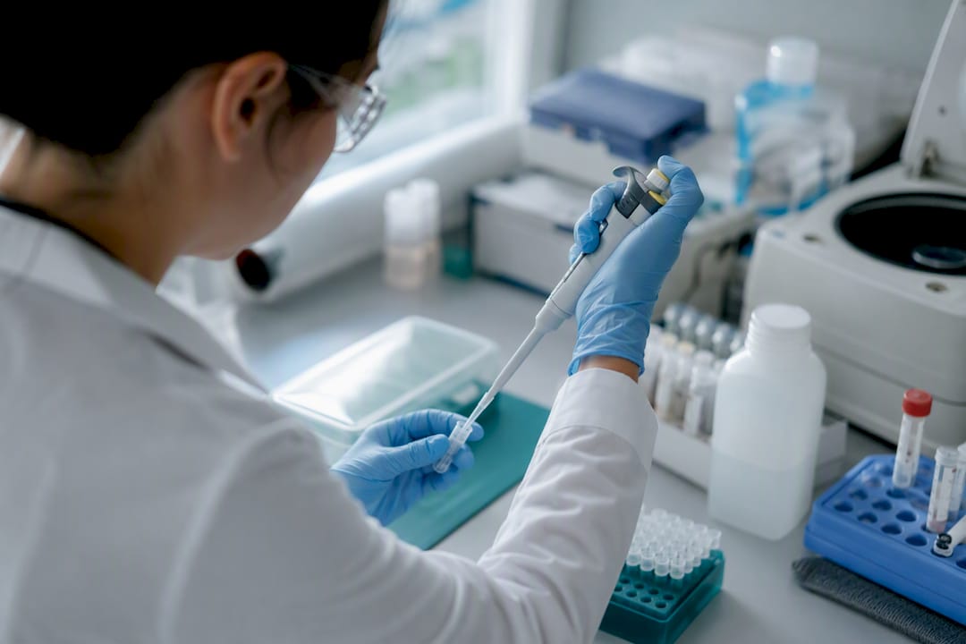 Hands preparing NAAT sample in lab