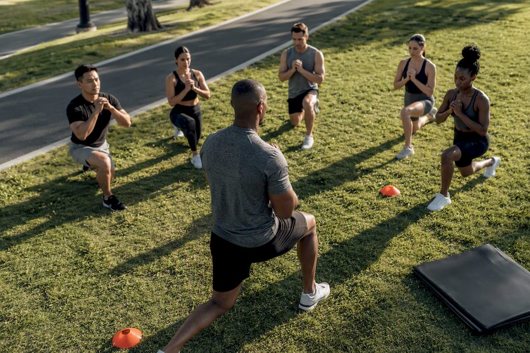 Trainer leading outdoor bodyweight bootcamp