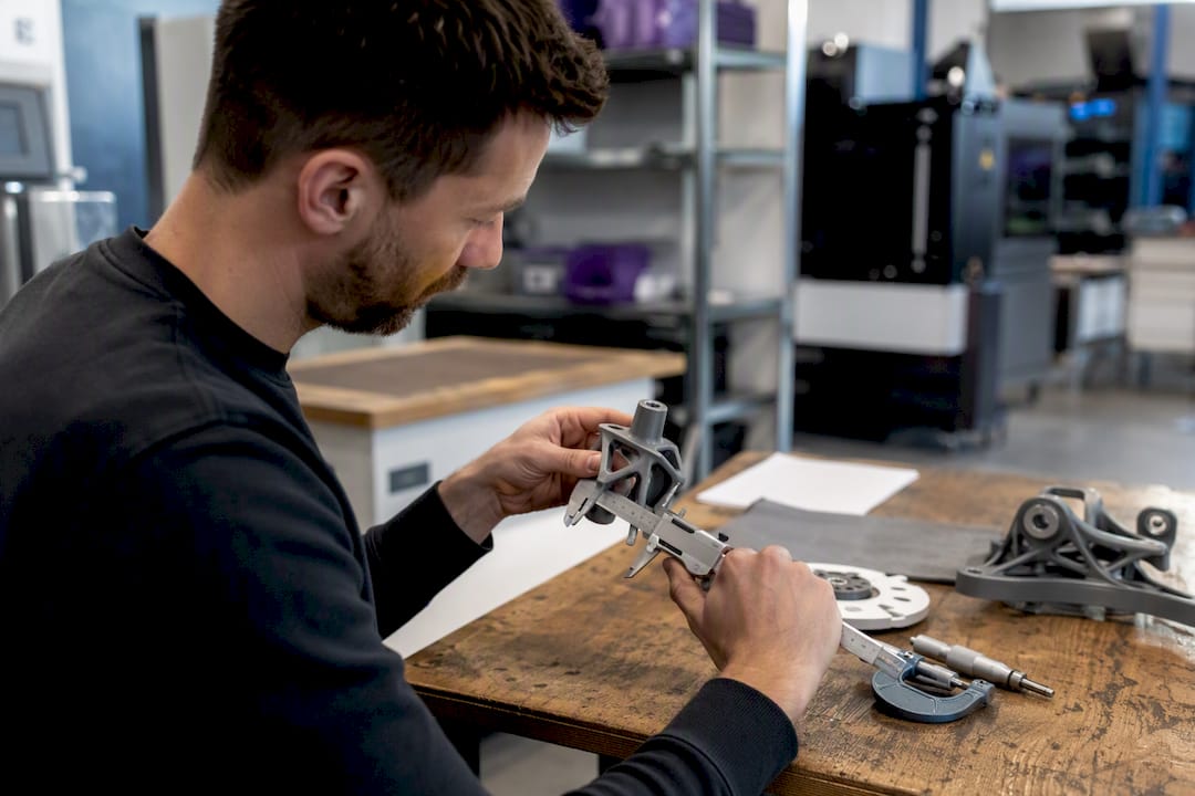 Ingénieur mesurant une pièce imprimée en 3D dans l'atelier