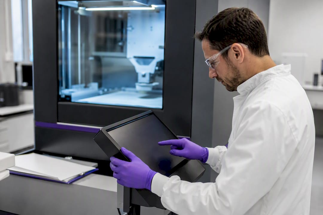 Opérateur réglant une imprimante 3D SLS pour pièces médicales