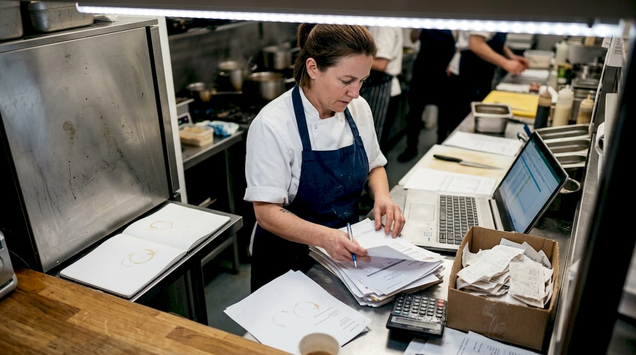 Chef preparing monthly paperwork in kitchen