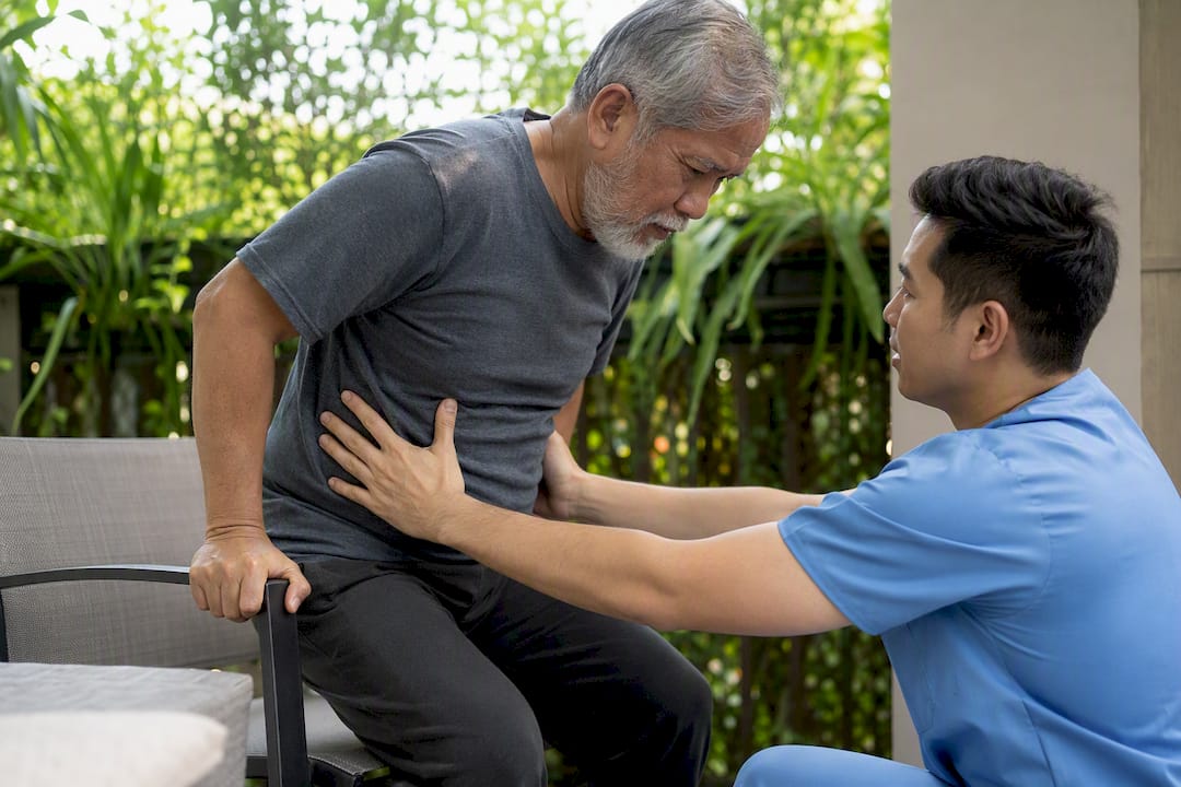 Physical therapist assists patient sit-to-stand exercise