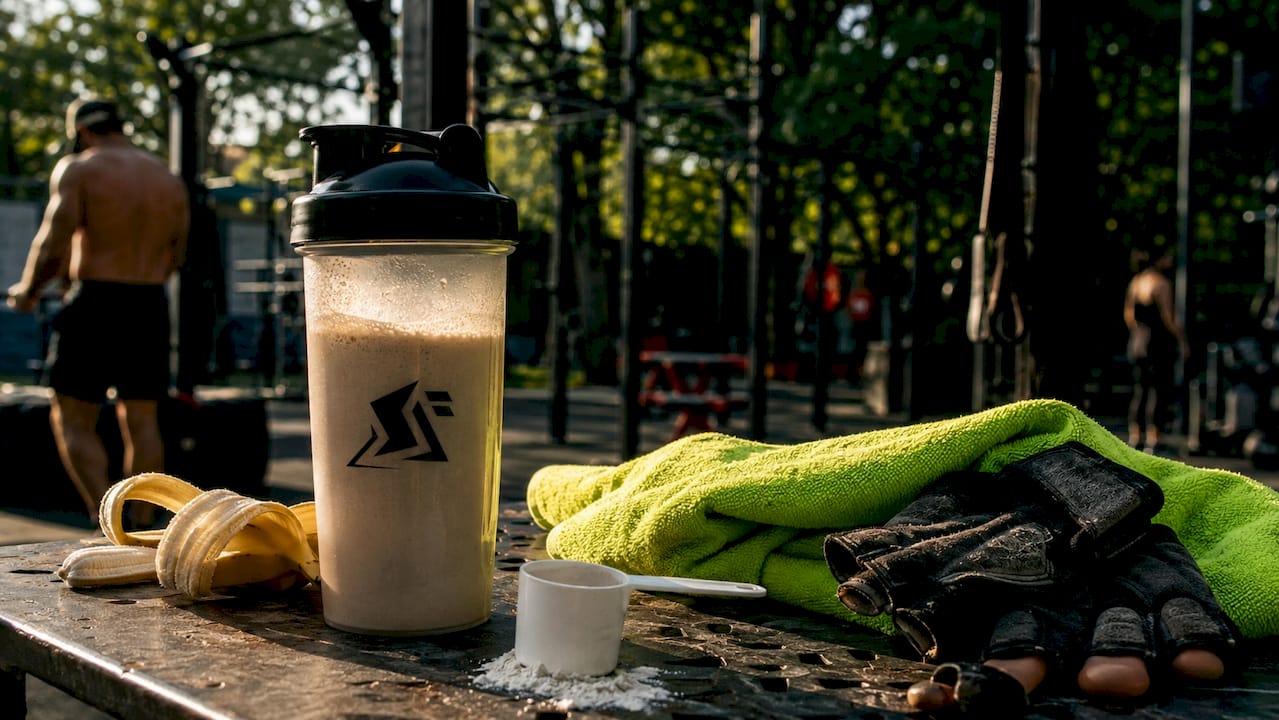 Creatine shake with gym accessories on bench