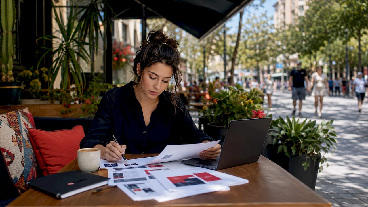 Small business owner reviewing advertising materials in café