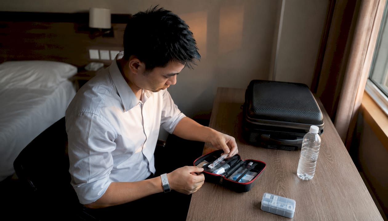 Hombre revisando suministros médicos en la habitación de un hotel