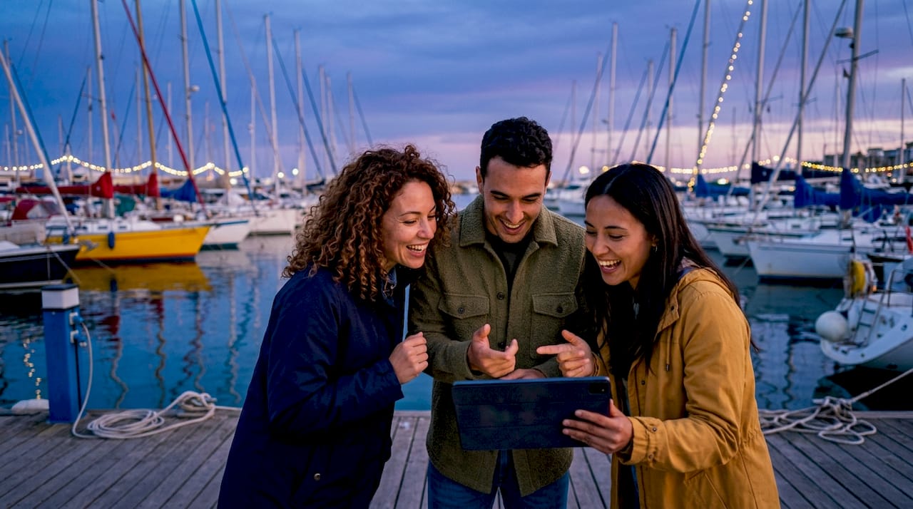 Group discussing sailing holiday costs by marina