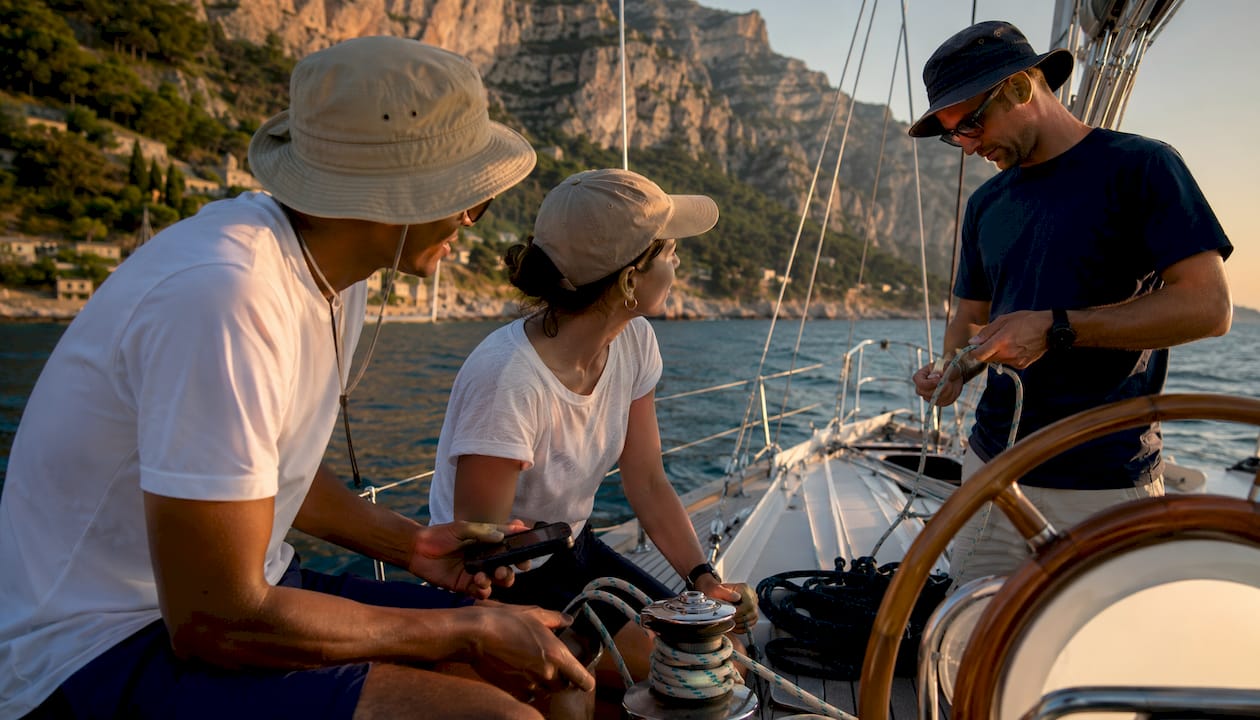 Sailors working aboard sailboat near French Riviera