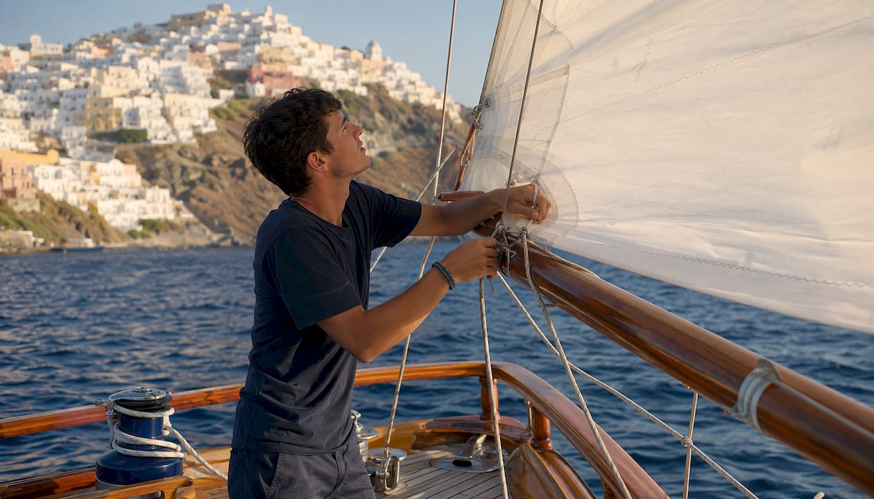 Close-up of sailor controlling tiller on Aegean yacht