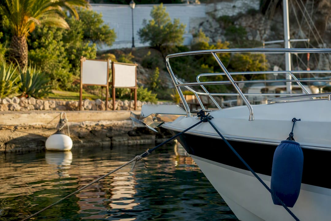 Yacht docked at Greek marina near pricing signs