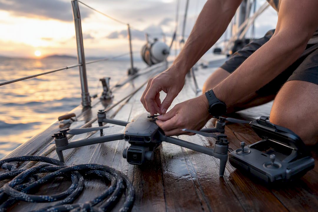 Hands calibrating drone compass on yacht deck