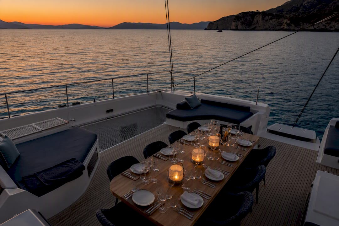 Catamaran deck set for dinner at sunset