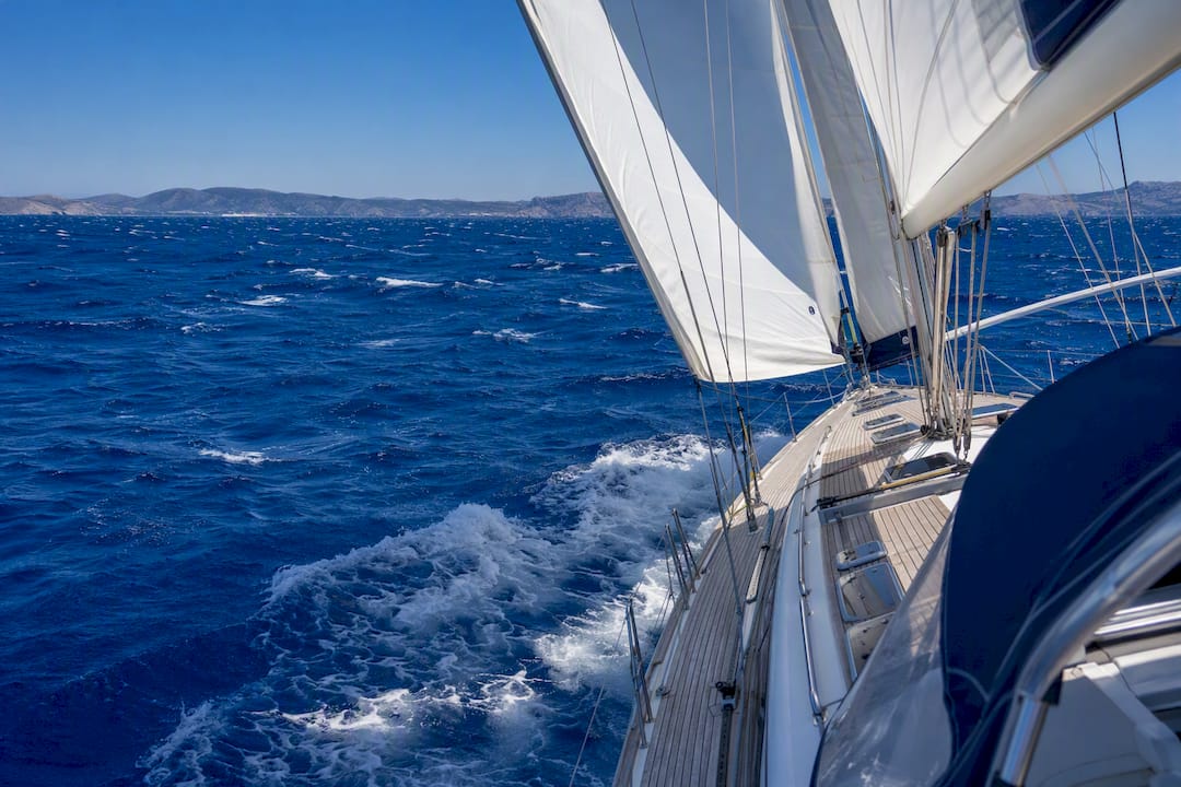 Sailboat mainsail filled by strong Meltemi wind in Aegean Sea