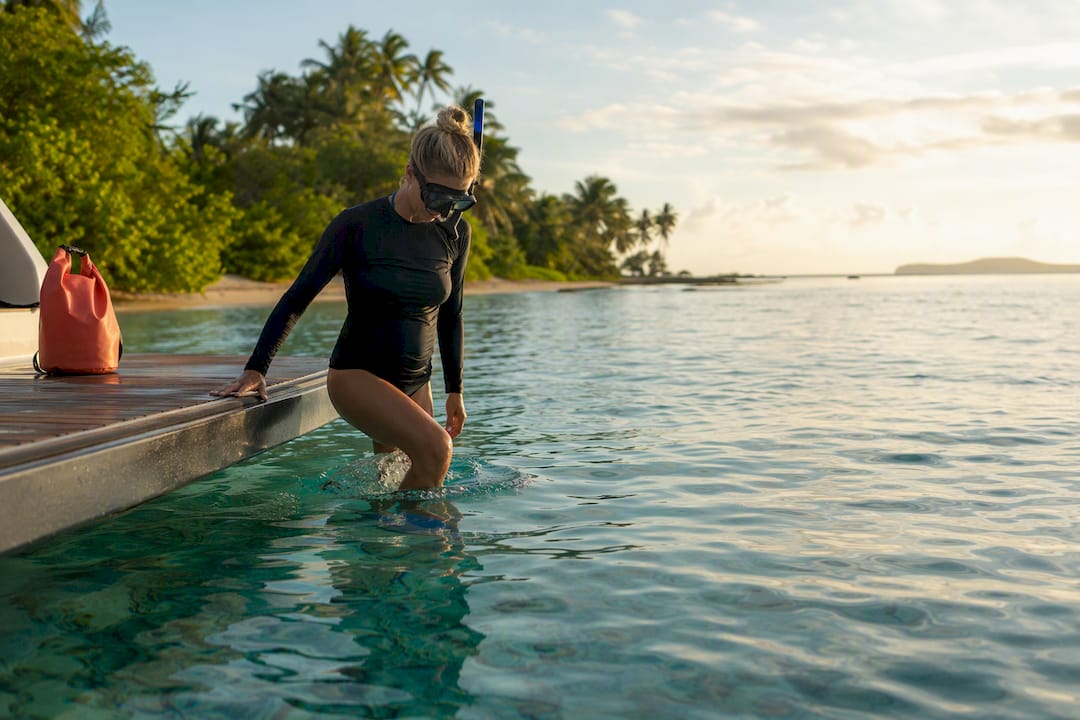 Traveler entering a calm Tahiti lagoon