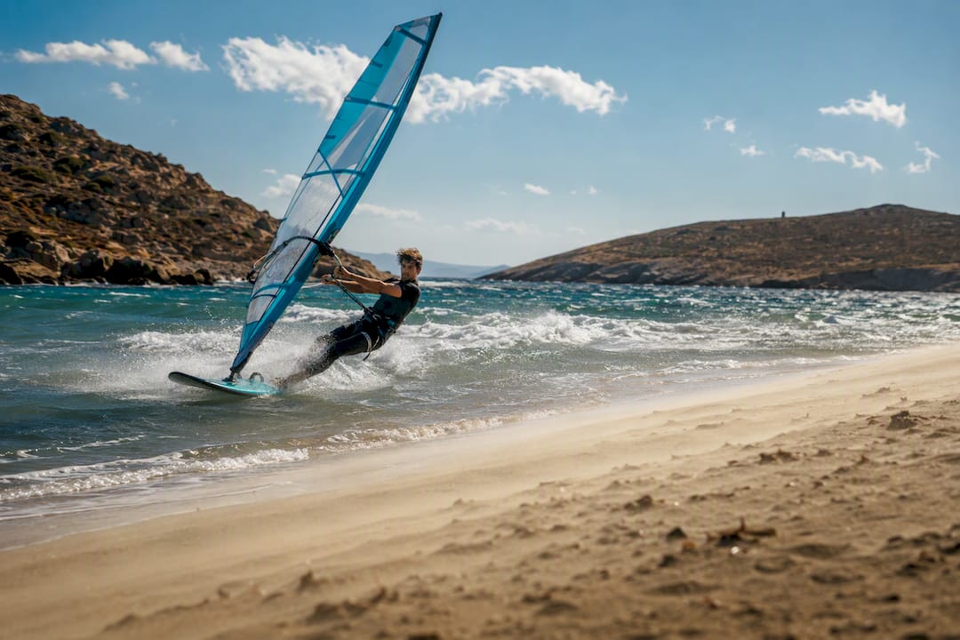 Windsurfer crossing a windy Cycladic beach
