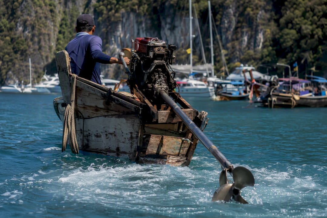 Long-tail boat crossing a crowded anchorage