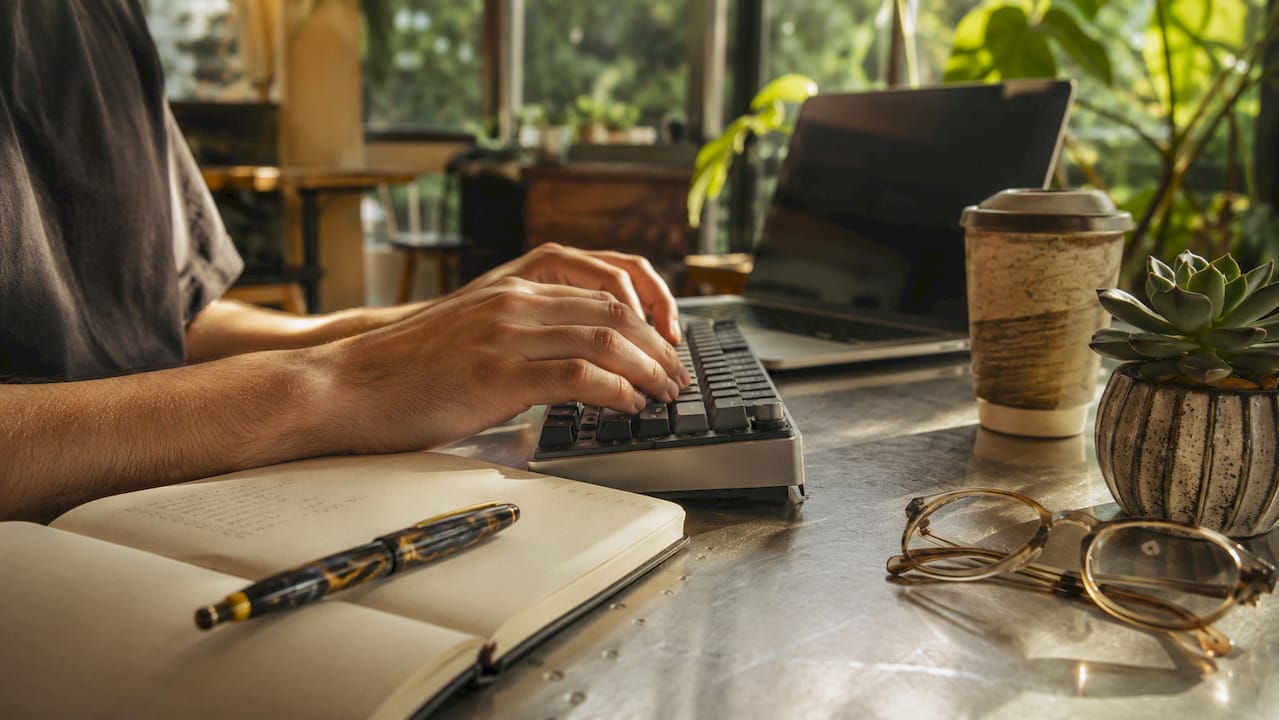 Hands typing keywords at minimalist desk