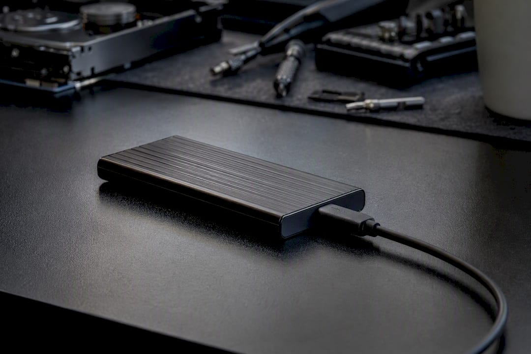 SSD inside USB enclosure and cables on repair bench