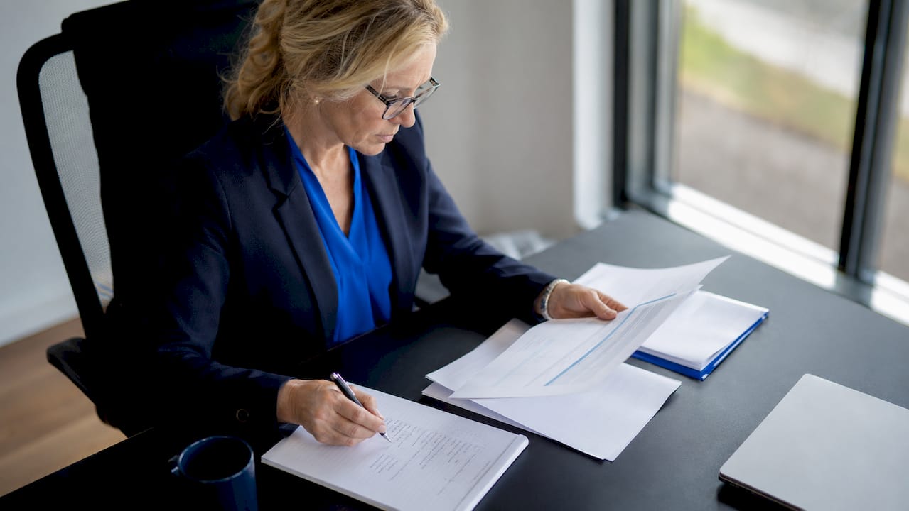 Een zakenvrouw verdiept zich in documenten over dividendbelasting.