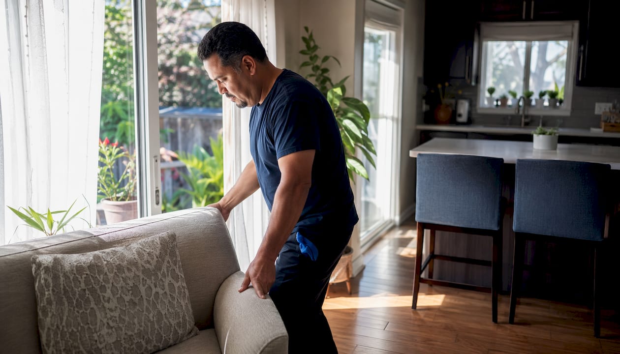Homeowner prepares living room window for cleaning