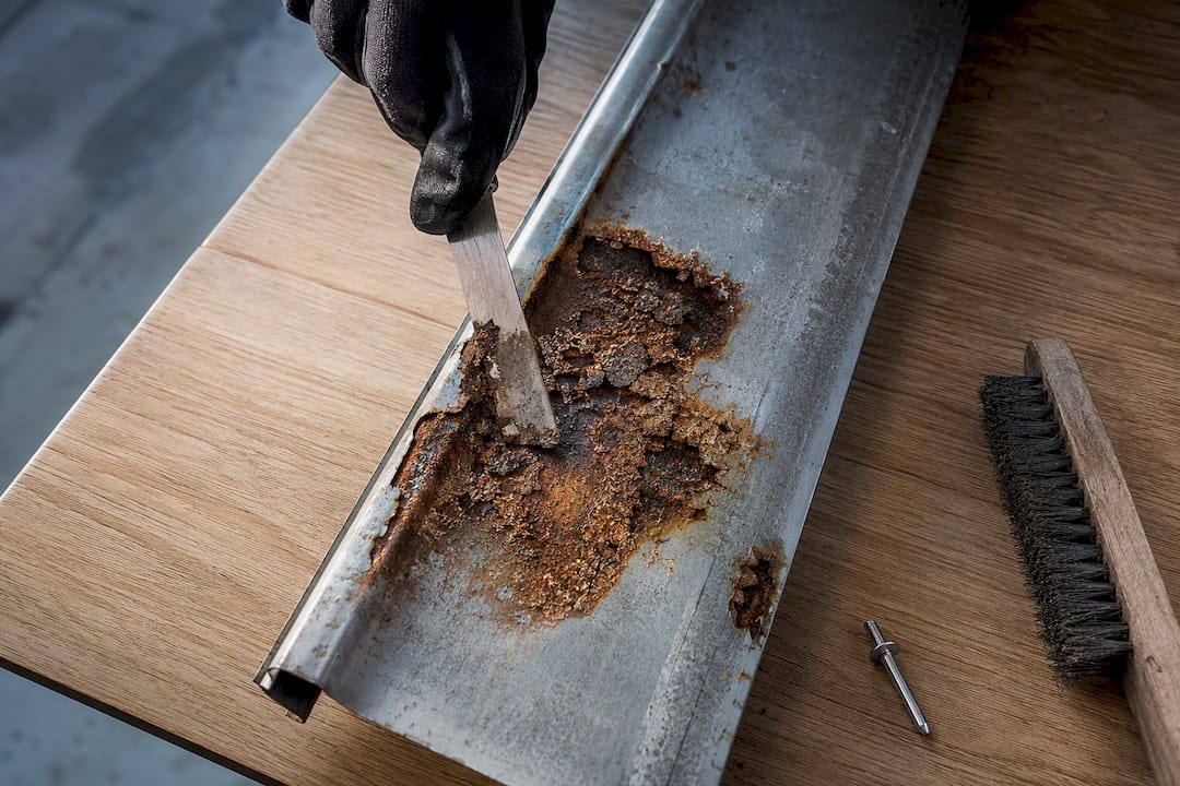 Scraped gutter section showing pitted corrosion