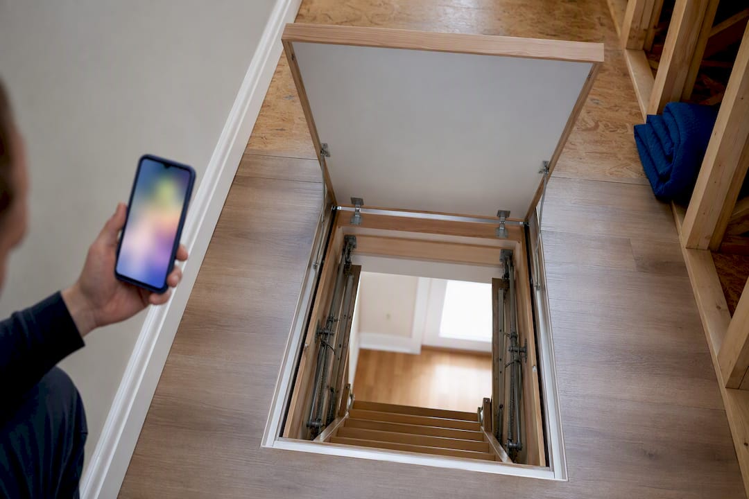 Homeowner photographing attic access points