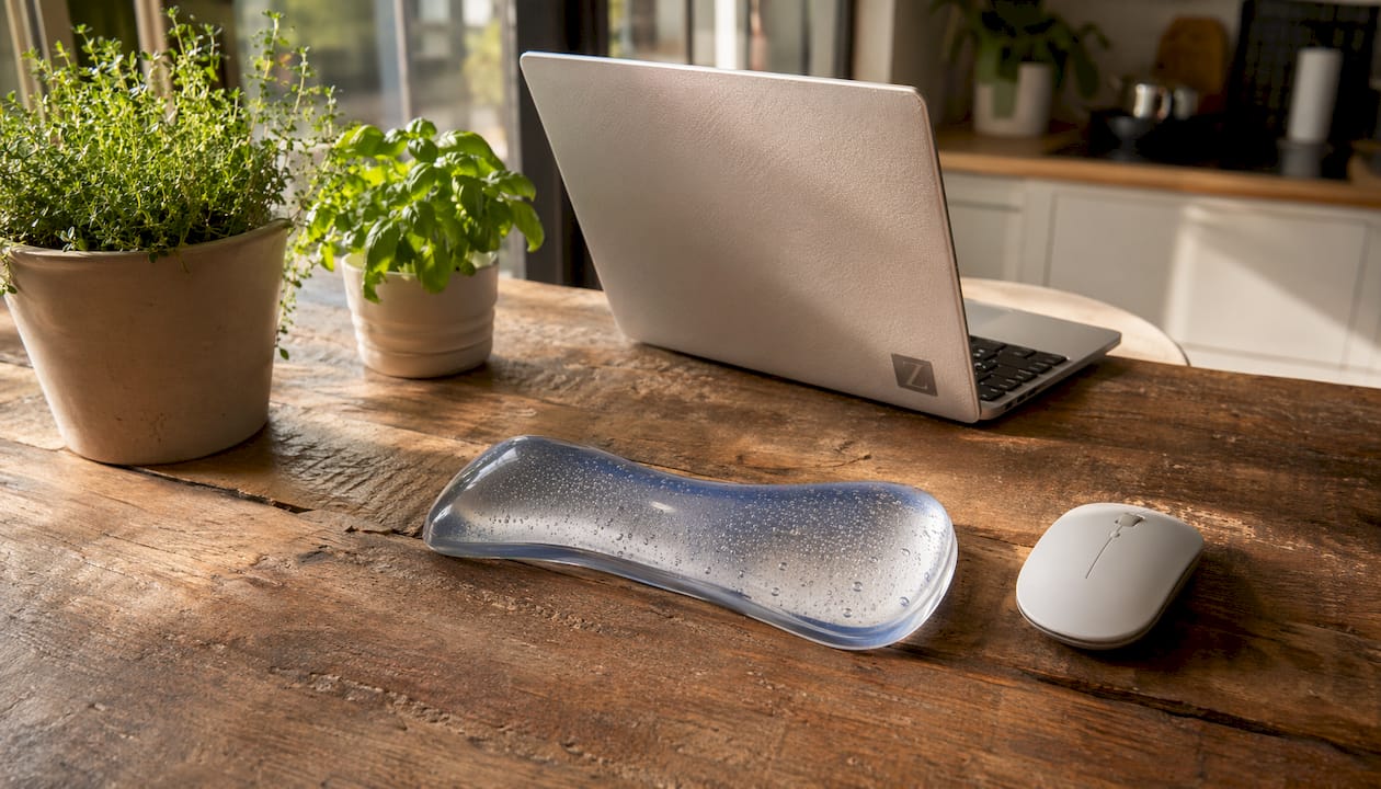 Gel-filled wrist pillow with ergonomic curve on desk