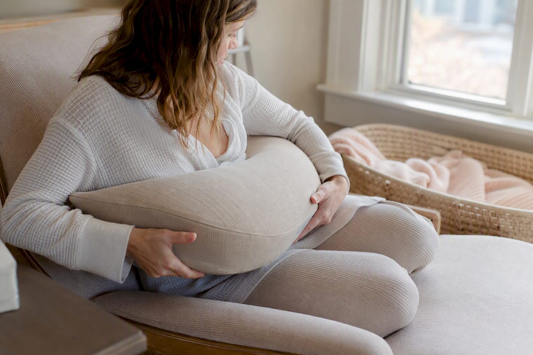 Mother positioning cushion under arm for feeding support