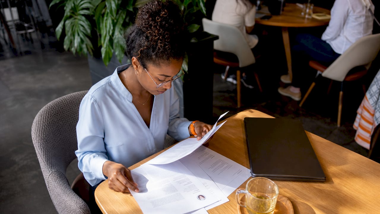 Recruiter reviewing candidate resumes at desk