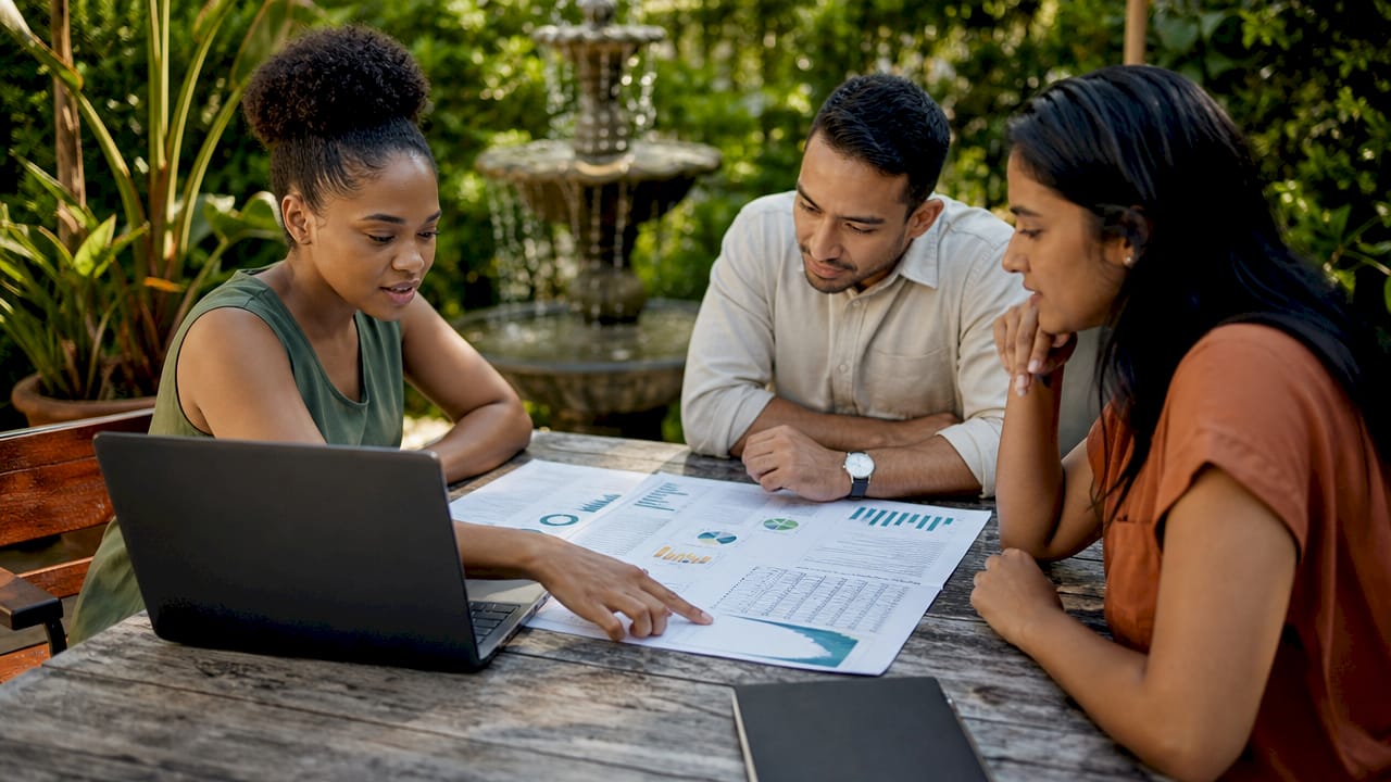 Hands analyzing data sheets on conference table