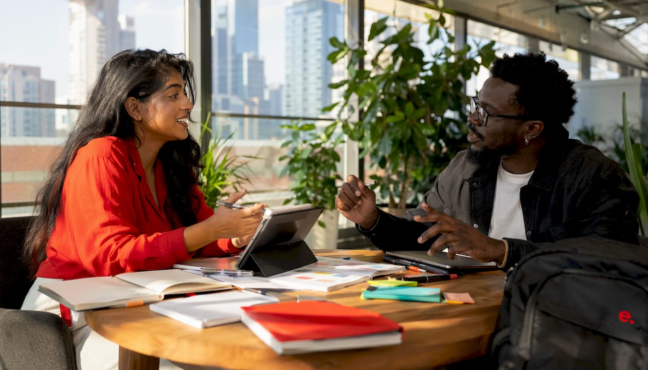 Offshore Creative Workflow Best Practices for Teams 2 Two creatives discussing designs in meeting room