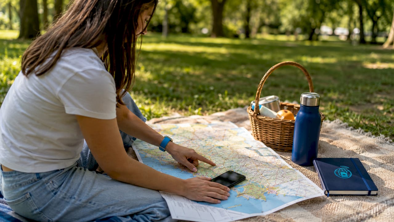 Close-up hands with phone on Albania map