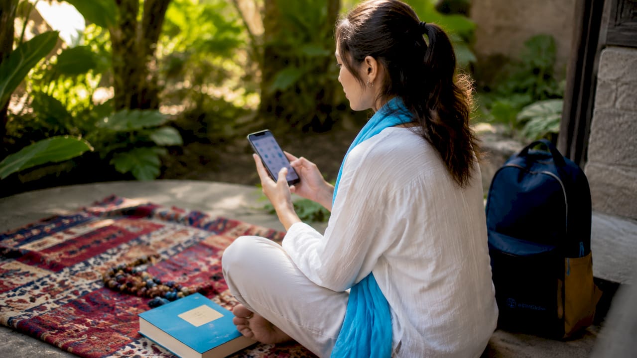 Hands holding smartphone with pilgrimage apps overhead