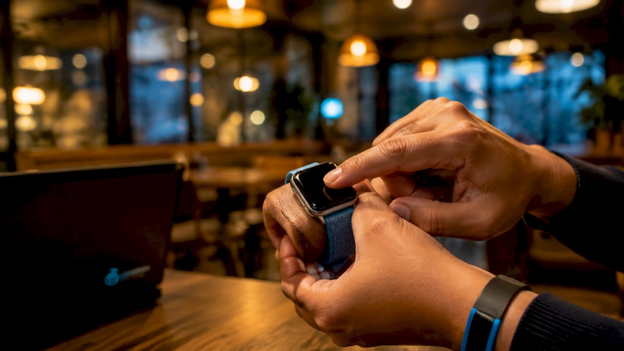Hands interacting with eSIM-enabled smartwatch