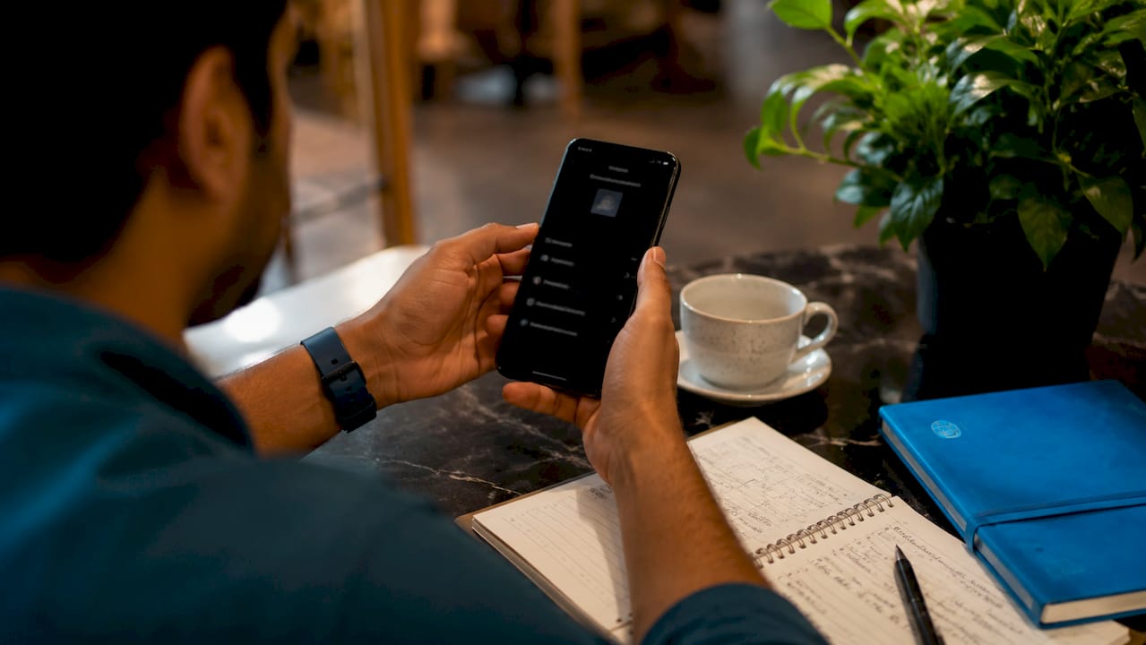 Close-up hands with phone activating eSIM in café