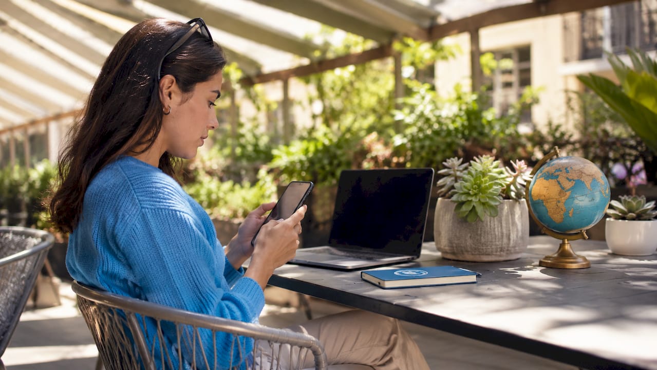 Hands activating eSIM on smartphone at home desk