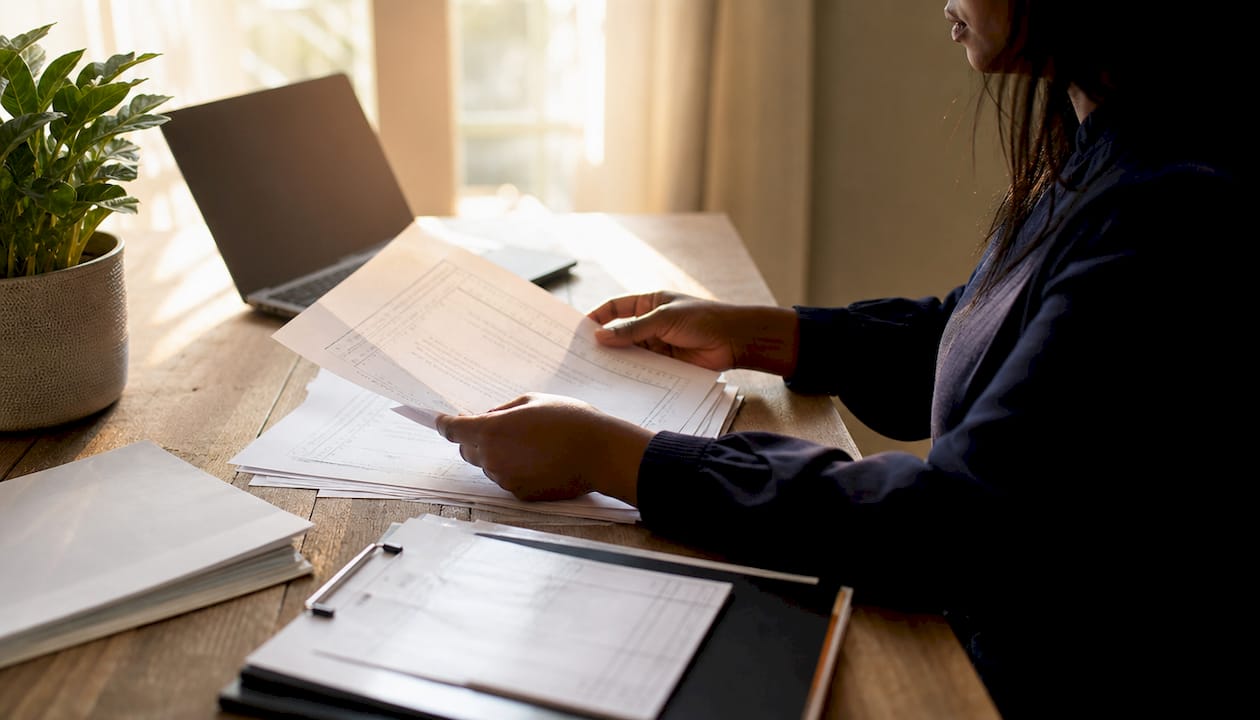Close-up of auditor's hands with IT asset documents