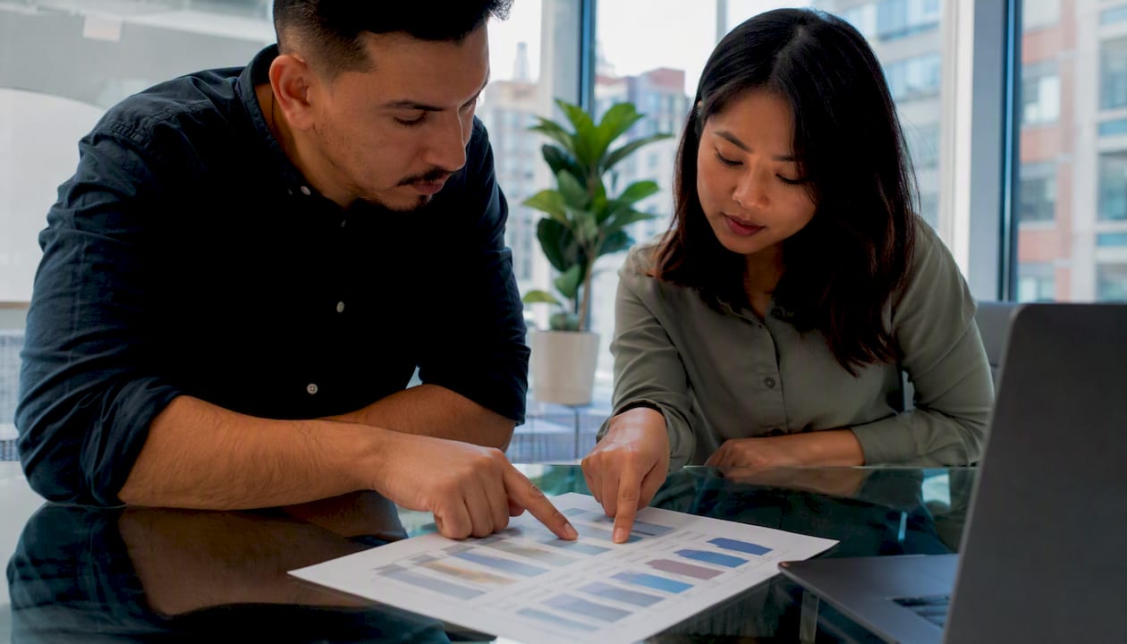 Two professionals reviewing ITAD comparison chart